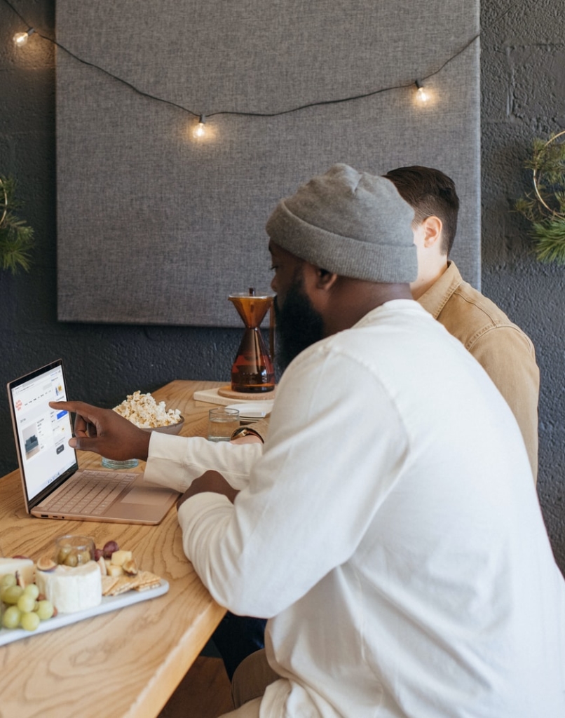 Two people collaborating on their Surface laptop sitting on a table at work